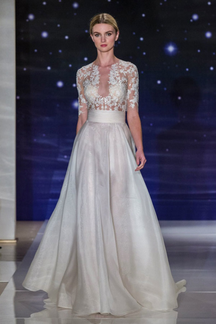 Reem Acra Bridal Spring 2016。雷姆·阿克拉2016纽约婚纱周春夏婚纱发布。本季系列表达了“每一位新娘都是明星”的想法，以闪耀的蕾丝细节融入大部分的婚纱设计，设计师想要达到一种设计的平衡，在繁华的装点之余也有更多真丝绉纱、斜纹布的简约款式。Acra的礼服更多的是对女性性感的一种表达：低胸、紧身的胸衣、透明的薄纱都无限了属于女性最动人的一面，让穿上婚纱的姑娘犹如夜空中那颗最美的星星。