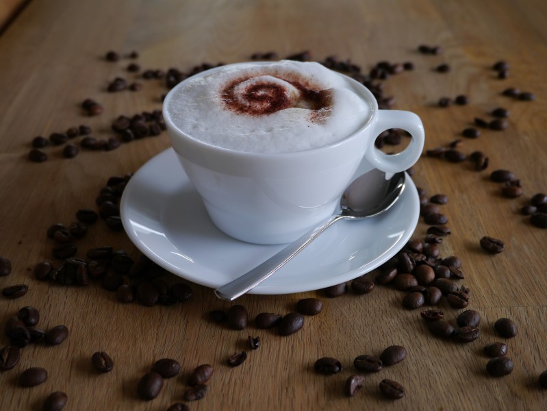 咖啡豆散落在装有咖啡的杯子旁图片(10张)