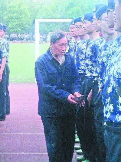 老人在大学新生军训队伍里＂检阅式＂行乞