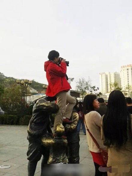 陕西延安女游客为拍照坐红军雕塑头上
