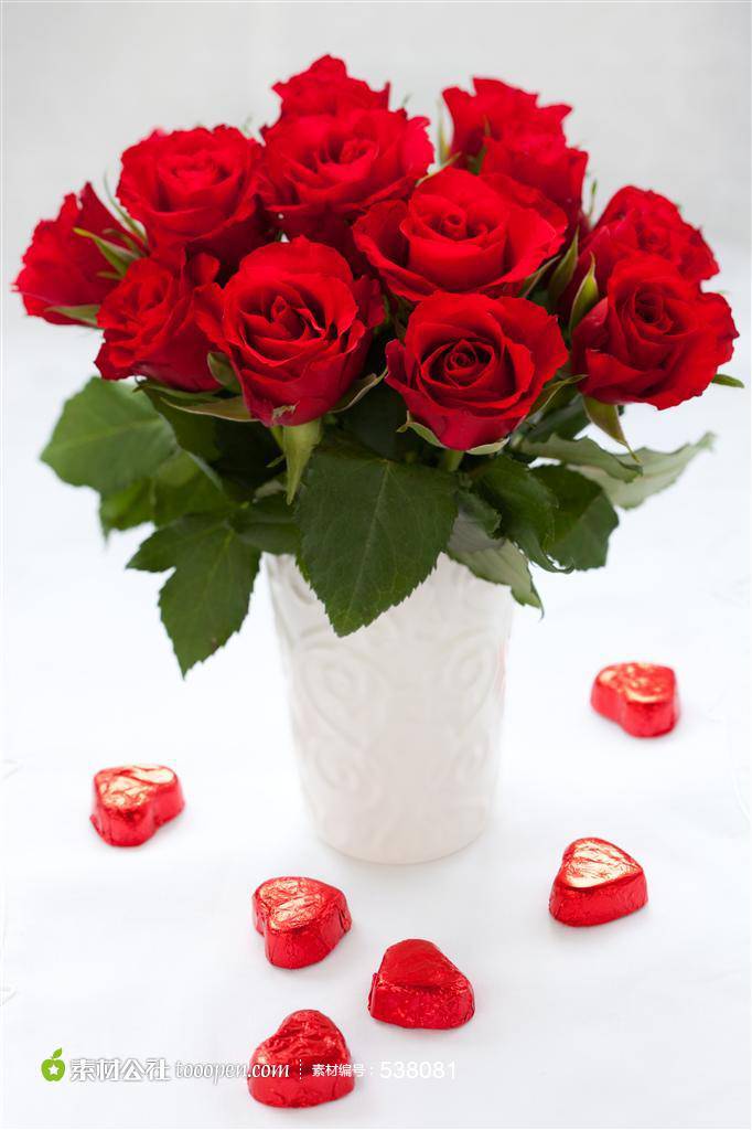 白色花瓶中的红玫瑰和心形巧克力图片