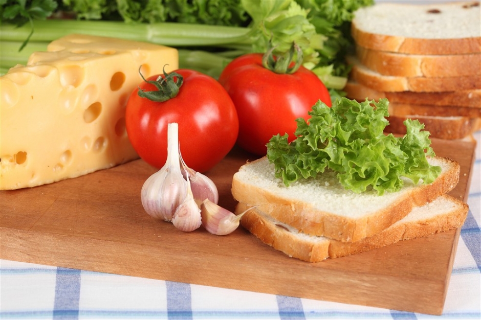 砧板上的切片面包跟西红柿等美食