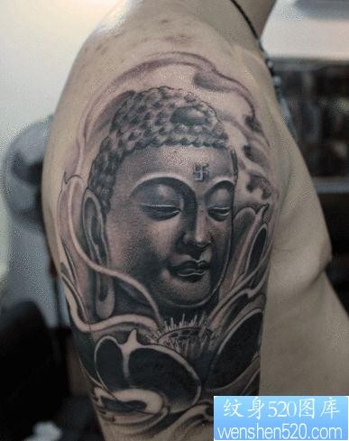 一张男生手臂经典的佛头纹身图片