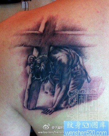 男生肩背一张黑灰耶稣纹身图片