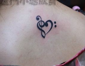 女人背部一幅图腾音符爱心纹身图片