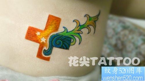 女孩子腰部一幅精美的彩色十字架纹身图片