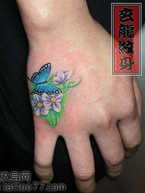 美女手背彩色蝴蝶花卉纹身图片