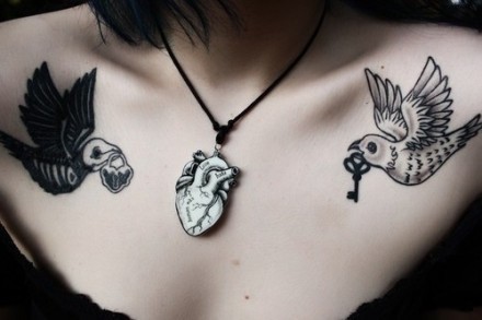 女性胸前两只燕子刺青