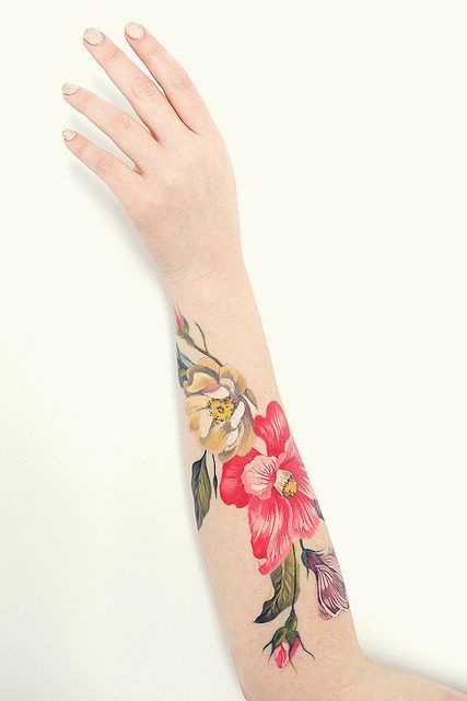 女性手臂上花朵和小鸟纹身