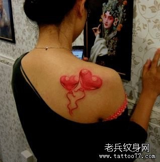 女人肩背一幅彩色爱心纹身图片