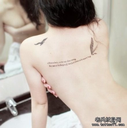 一幅性感女人背部羽毛字母纹身图片由纹身520图库推荐