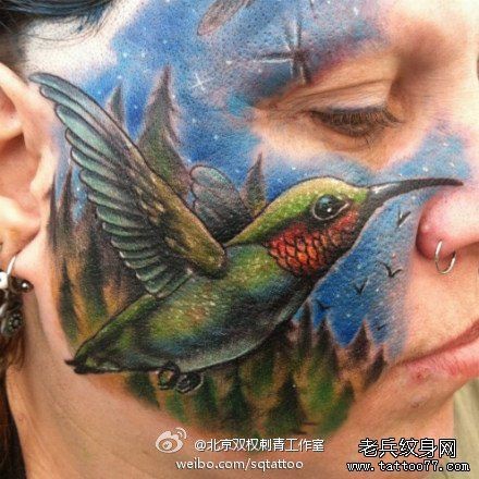 一幅另类的欧美女性脸部蜂鸟纹身图片