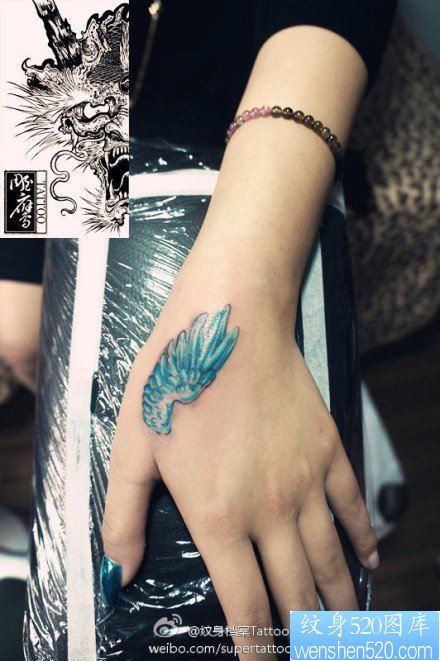 女人手部虎口彩色小翅膀纹身图片