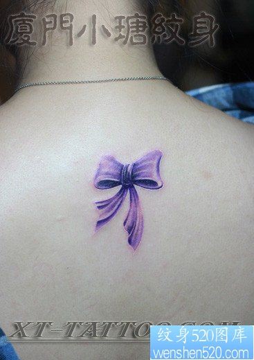 女人背部彩色蝴蝶结纹身图片