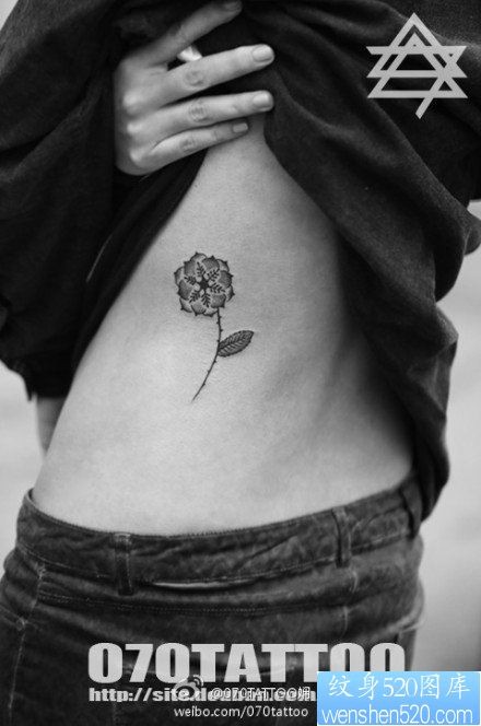 女人腰部雪花与花卉纹身图片
