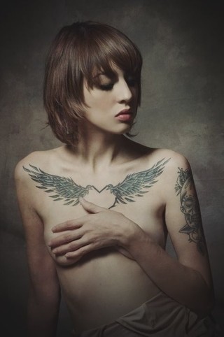 女性胸前羽翼刺青