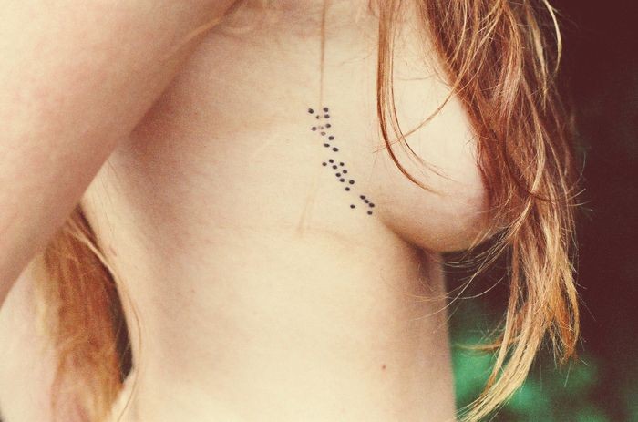 女性胸部小小的刺青点纹身