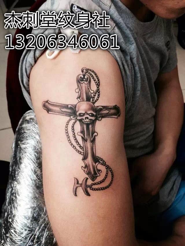 大臂上帅气的十字架骷髅纹身