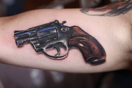 手臂上一款帅气的手枪纹身