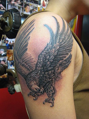 大臂上展示飞翔的老鹰纹身