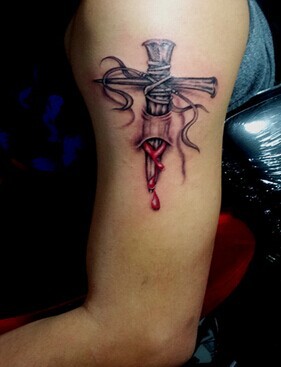 大臂上带血的十字架纹身