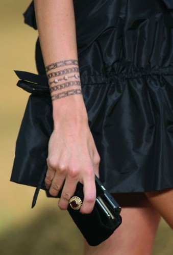 美女手臂上一串漂亮的手链纹身