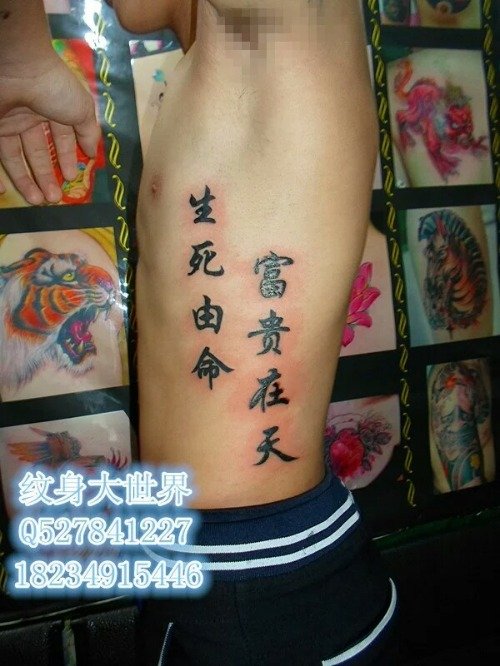 男子侧肋上的黑色中文纹身图案