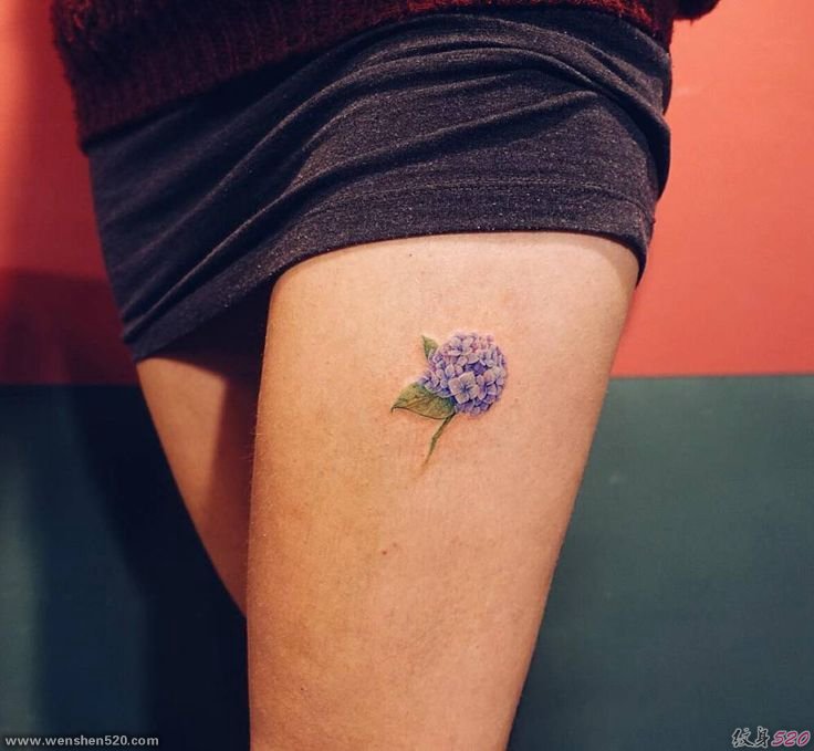 女性左大腿上淡雅的紫色小花纹身图片