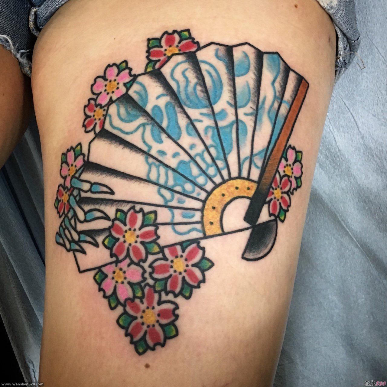 女性左大腿上的樱花和扇子纹身图片