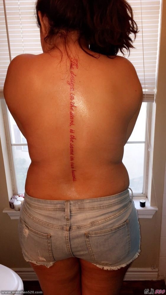 女子背部脊椎骨上一行红色的英文字纹身图片