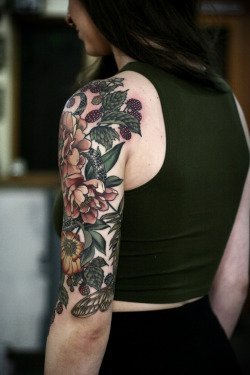 女性左手大臂膀漂亮的花朵纹身图案