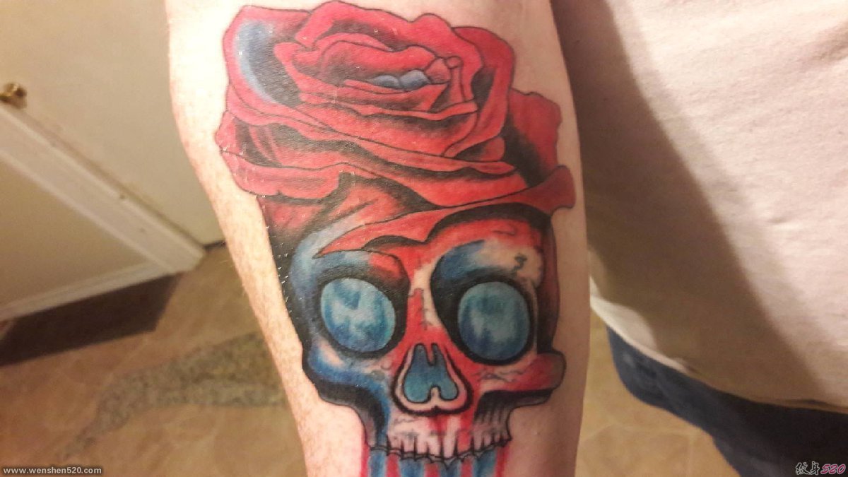 手臂上的红艳玫瑰花骷髅头纹身图片