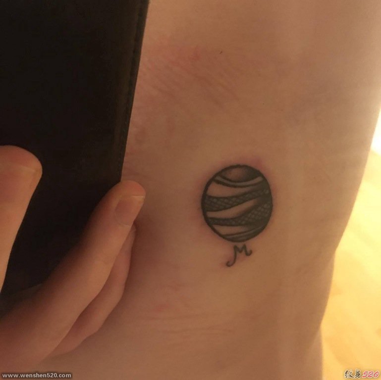 手臂上黑色的金星纹身星球图片