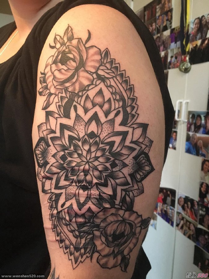 女性左手大臂上遮盖伤疤的精致的花卉纹身图片