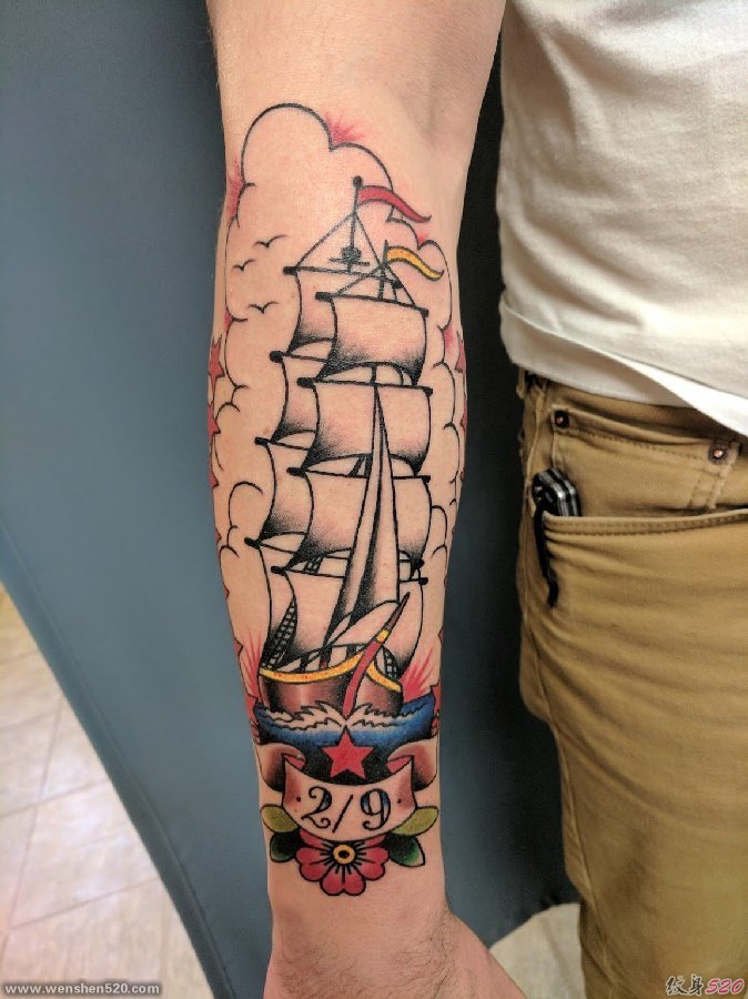 男性手臂上帅气的彩色纹身小帆船图片