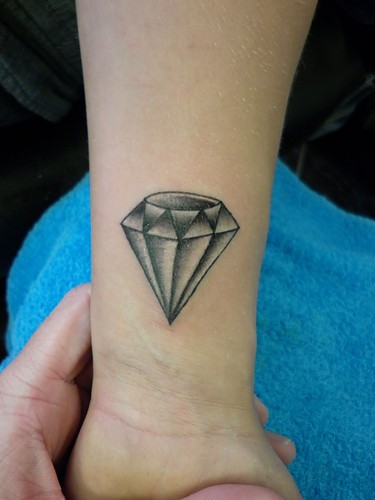 手腕上一颗淡色的钻石纹身
