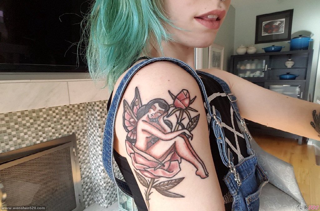 美女右手臂上彩色的玫瑰花和蝴蝶仙子纹身图片
