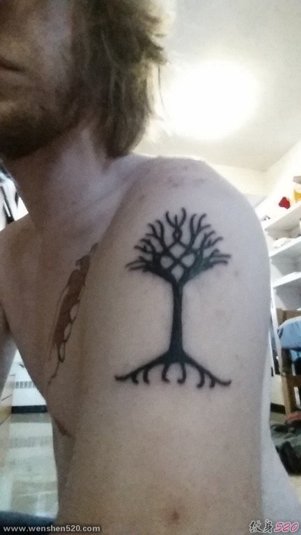 男性左手臂上黑色的小树图腾纹身图片