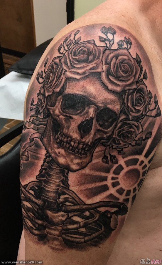 男子右手大臂膀上的黑灰色玫瑰花骷髅头纹身图片