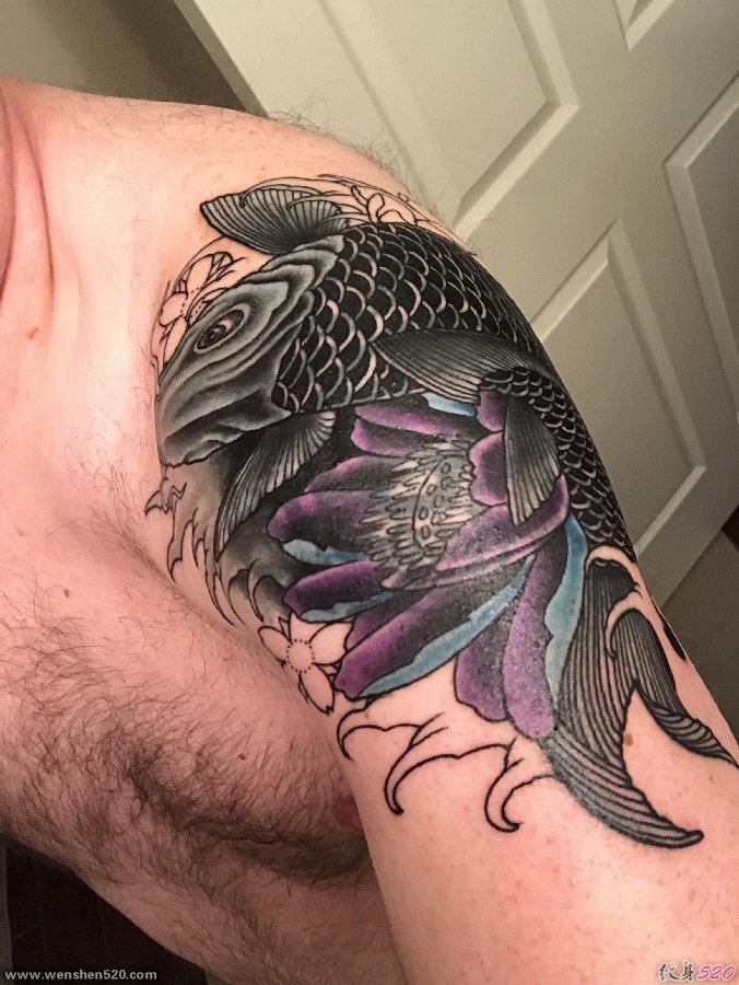 男子肩膀上的大黑色鲤鱼和蓝紫色莲花纹身