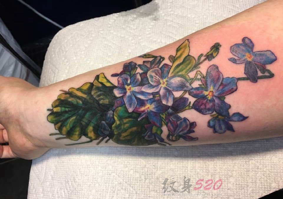 男生手臂上彩色渐变植物花朵纹身图片