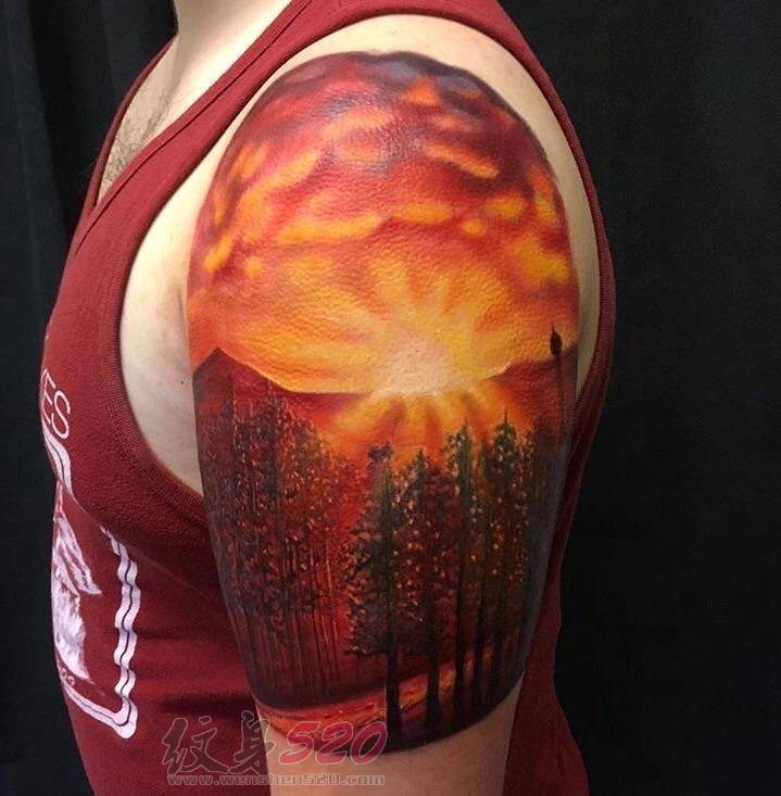 男生手臂上彩绘抽象线条树和日落风景纹身图片