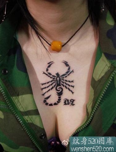女性前胸黑色的蝎子和字符纹身作品