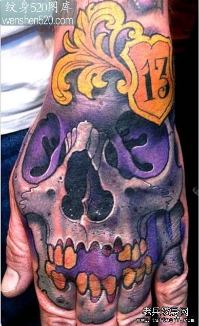 手背上一张紫色骷髅纹身图案