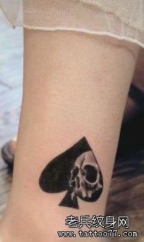 女孩子腿部一张黑桃与骷髅纹身图案