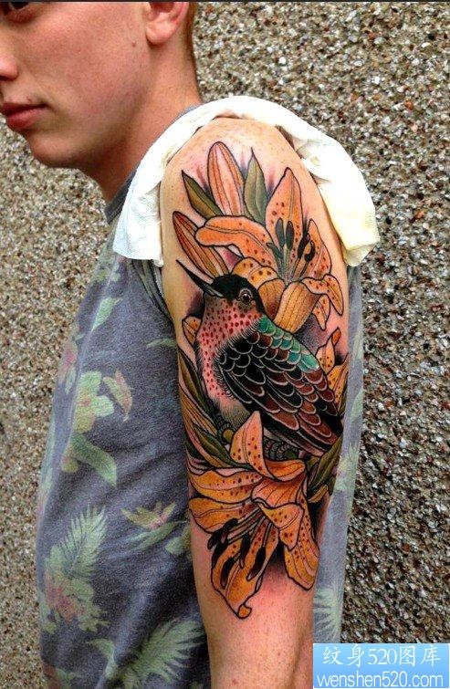 帅哥大臂上一张漂亮的百合花鸟纹身图案