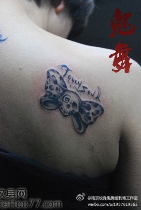 美女肩部流行经典的骷髅蝴蝶结纹身图片