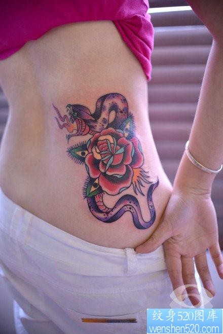 女人腰部前卫流行的蛇与玫瑰花纹身图片