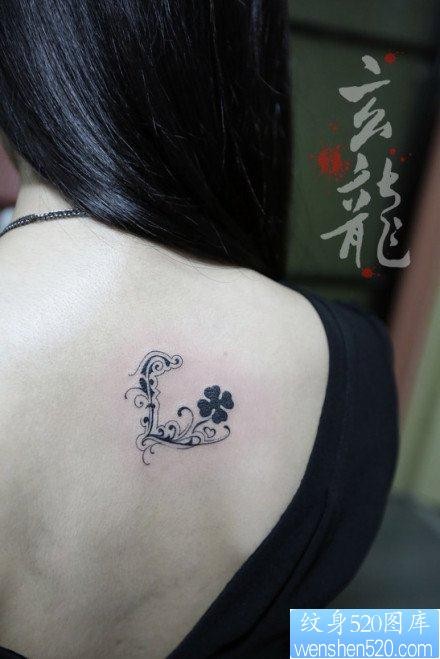女人后背小巧精美的花体字母纹身图片