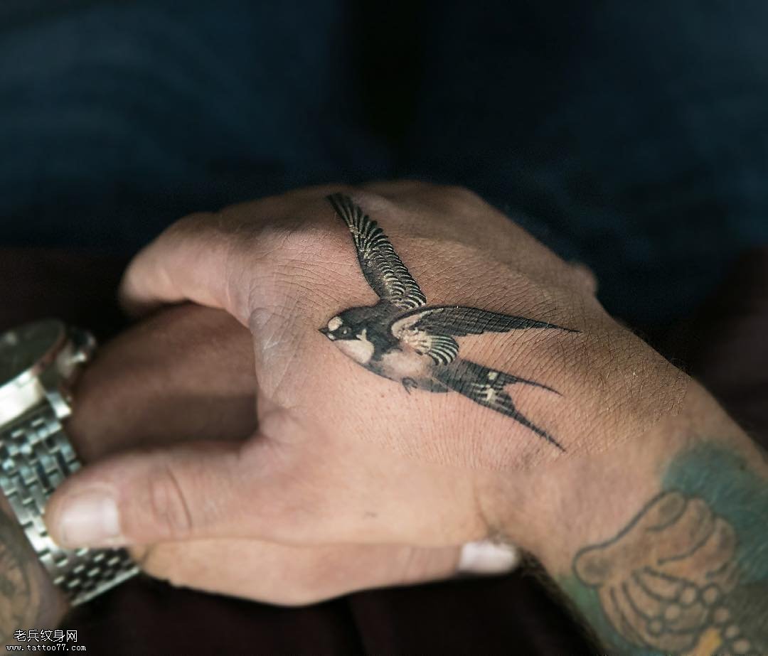 手背虎口处一只飞翔的燕子纹身图案